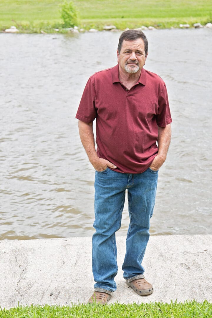 A man standing in front of the water.